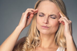 Frau mit starken Kopfschmerzen